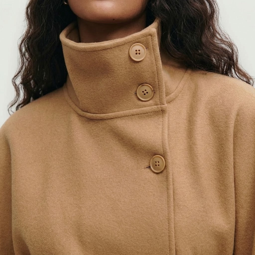 Woman wearing Snuvelle high neck batwing belted coat in a solid color
