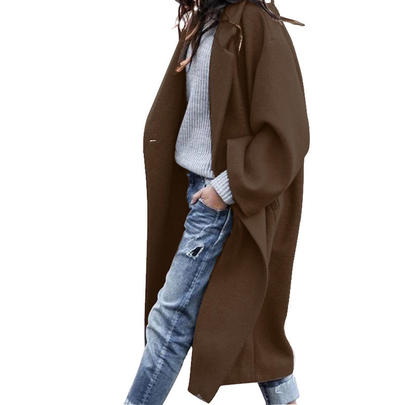 Woman wearing Snuvelle long single-breasted lapel coat with pockets